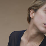 Model wearing ONOA necklace, a handmade ethical jewelry piece in recycled gold, showcasing timeless design.