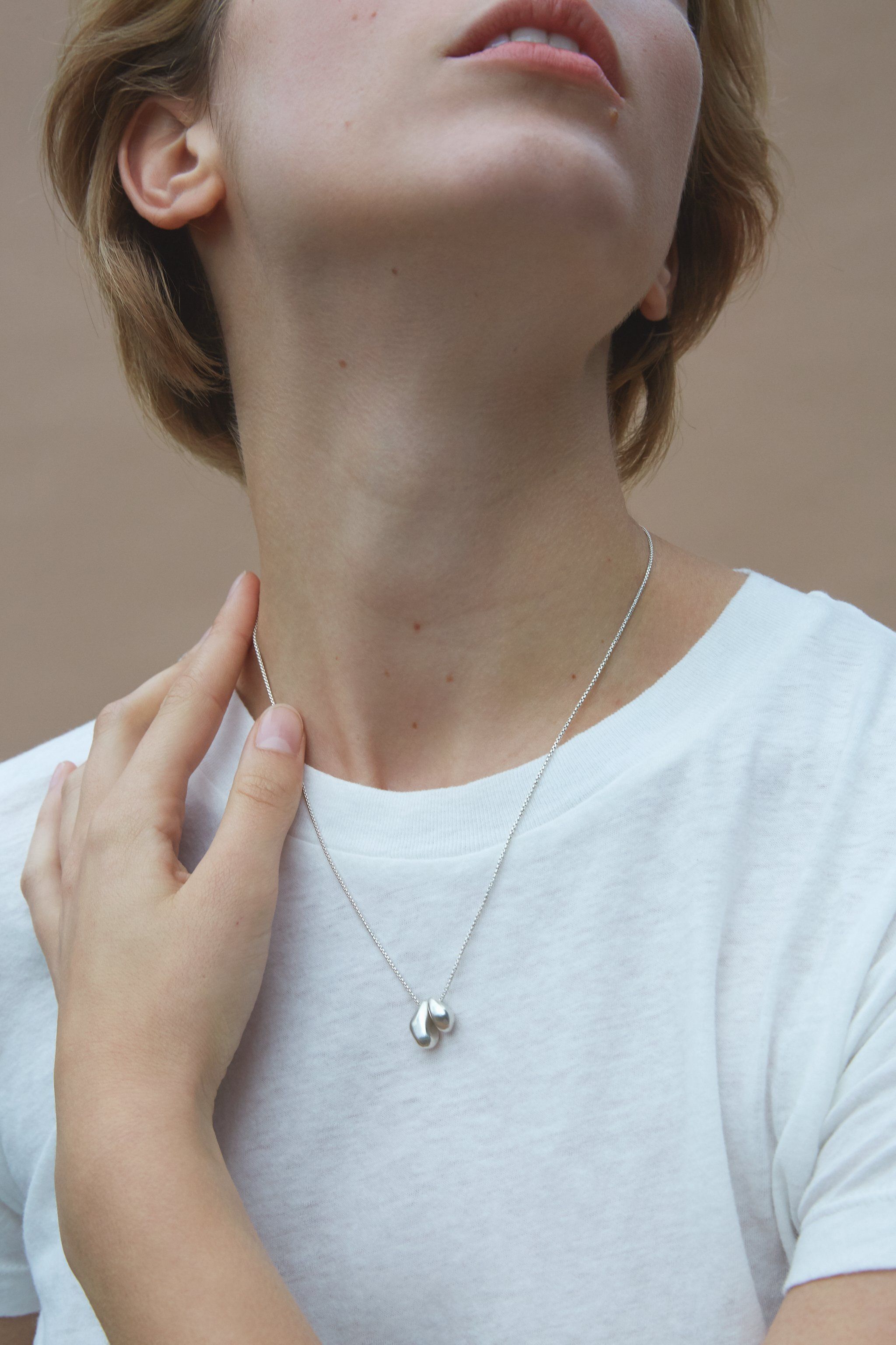 ONOA necklace worn by model, featuring handmade recycled silver and polished design, showcasing ethical and sustainable jewelry.