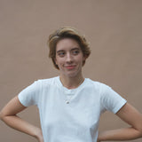 Woman wearing an ONOA necklace, showcasing ethical and sustainable handmade jewelry with recycled gold and silver.