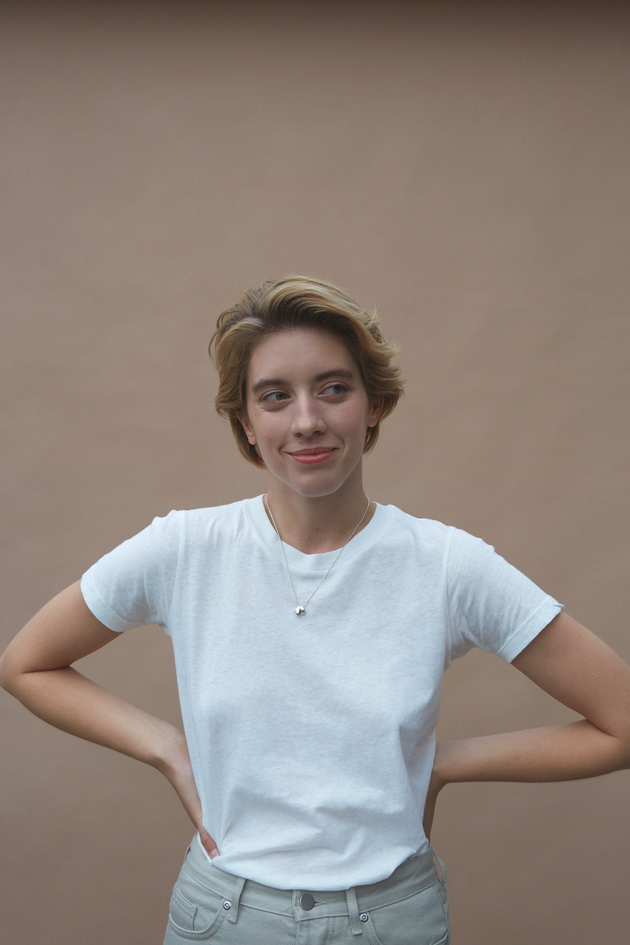 Woman wearing an ONOA necklace, showcasing ethical and sustainable handmade jewelry with recycled gold and silver.