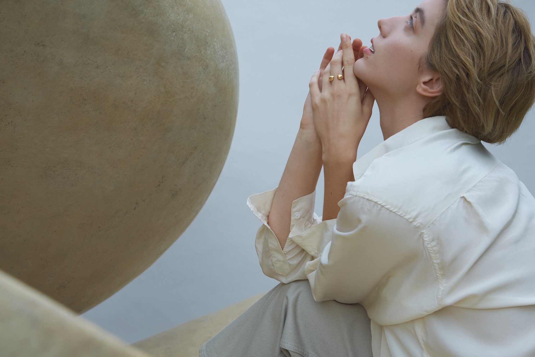 Close-up of a woman wearing the ONOA ring, showcasing its handmade, ethical design in a serene setting.