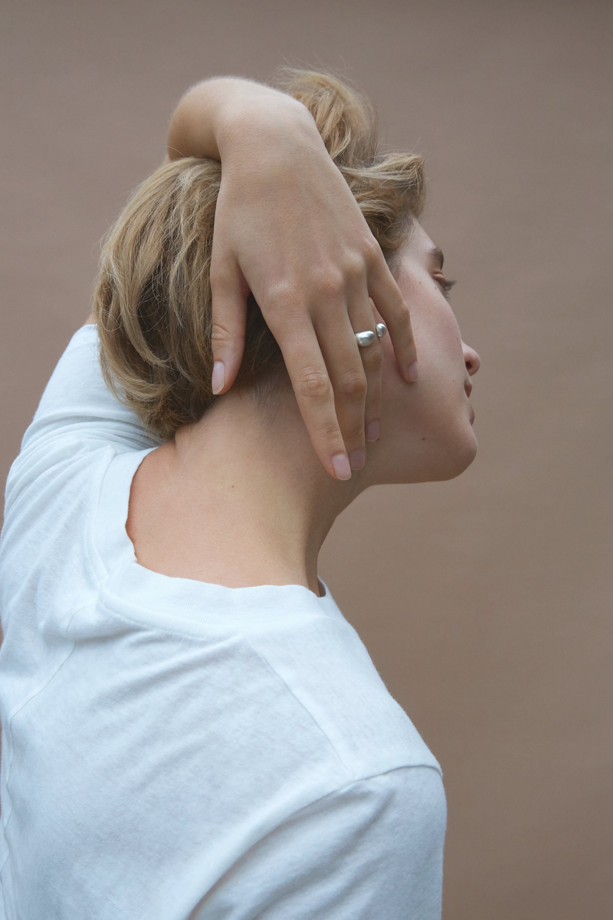 Woman wearing ONOA ring, showcasing ethical handmade jewelry made of recycled gold and silver.