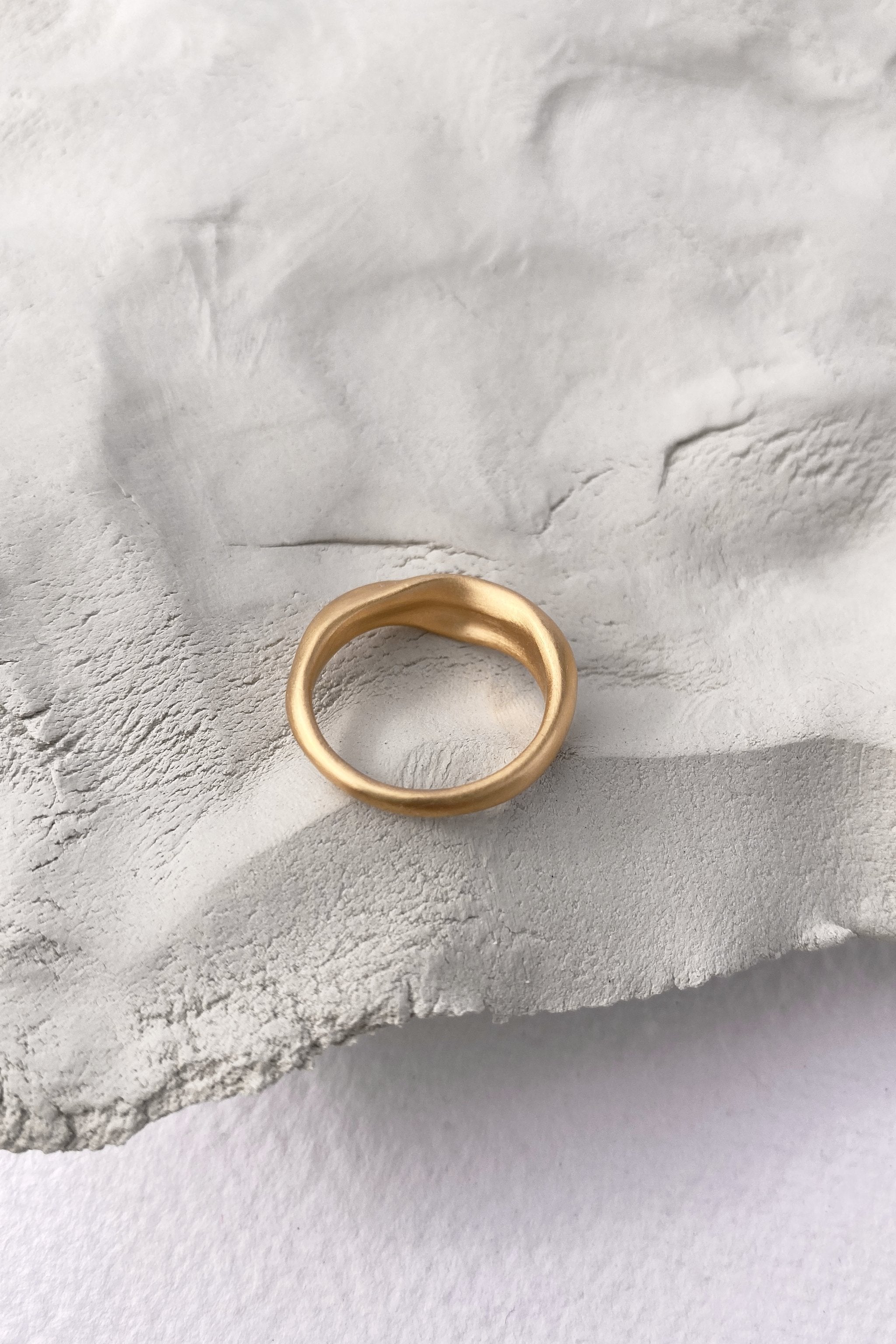 YERERA small ring, 18k gold-plated brass, handmade ethical jewelry on textured surface.