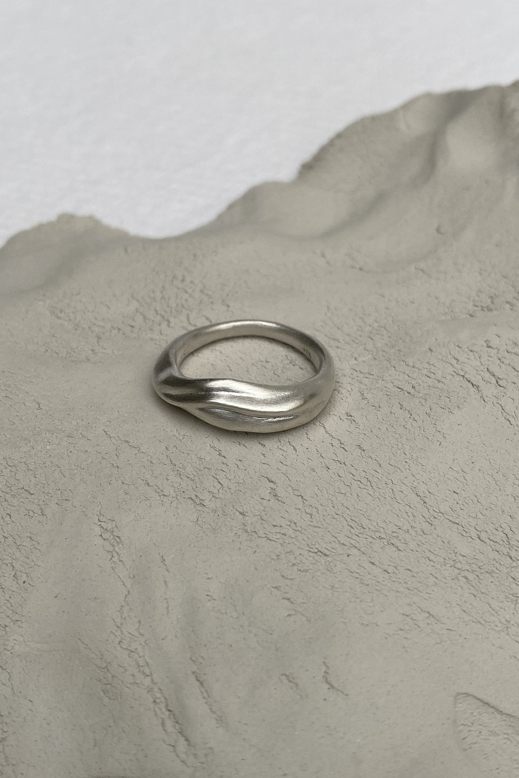 YERERA small ring made from recycled silver, showcasing a semi-matte surface on a textured background, ethical jewelry.