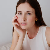 Close-up of a woman wearing PEBBLE earrings, showcasing ethical, handmade jewelry made from recycled silver.