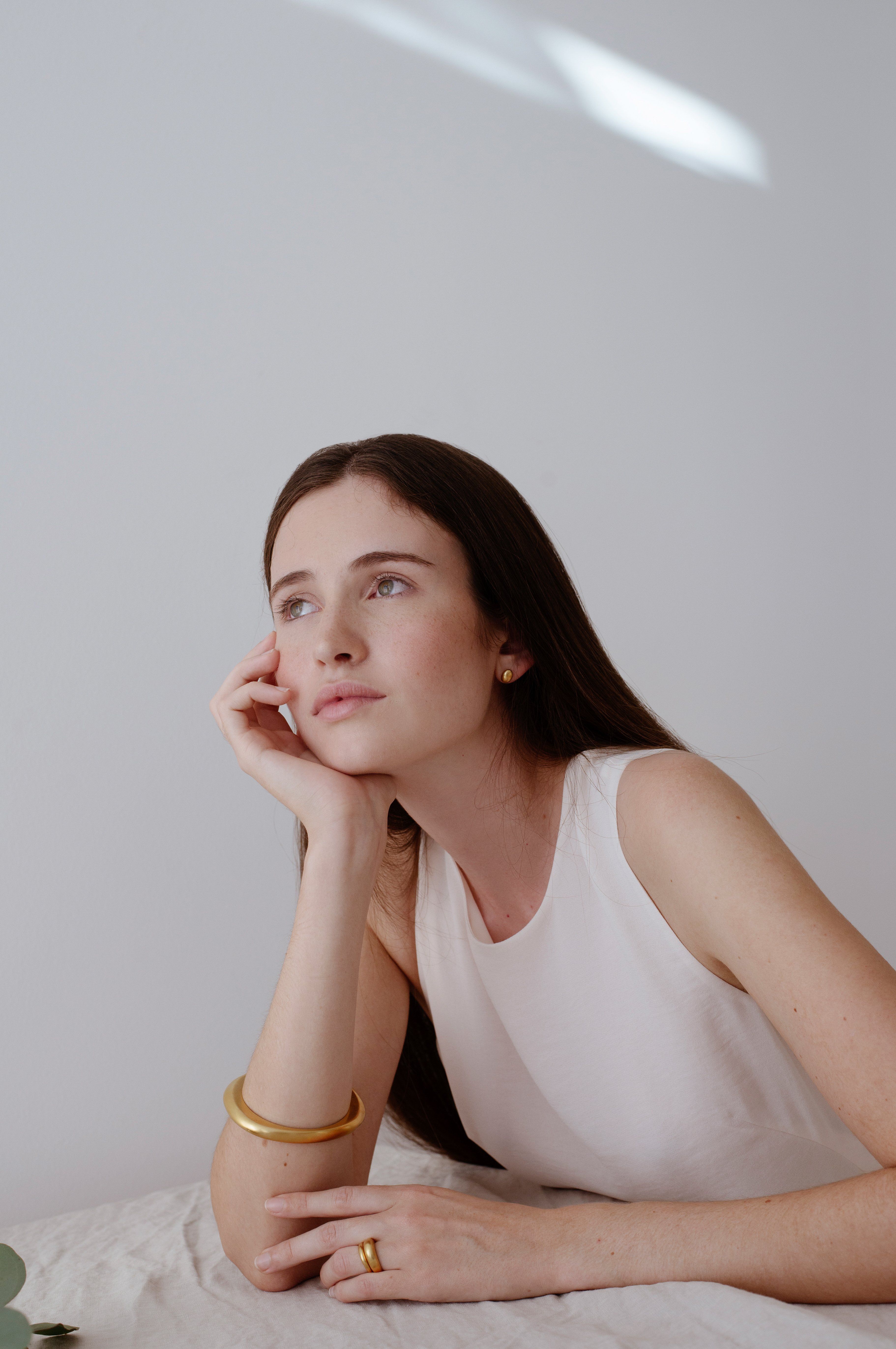 Model showcasing handmade PEBBLE earrings, emphasizing ethical sustainable jewelry and a timeless aesthetic.