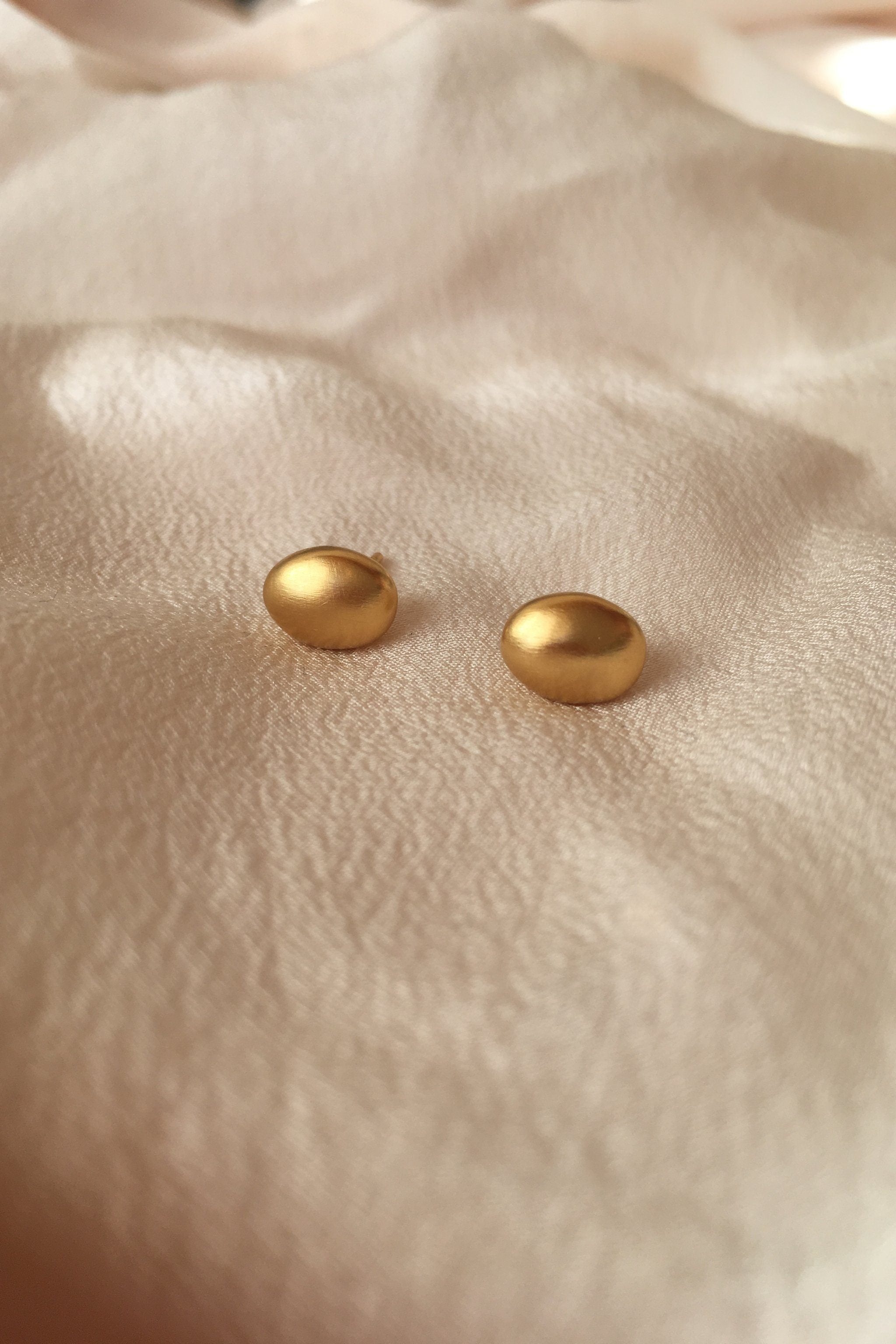 Handmade PEBBLE earrings in 18k gold-plated recycled silver on soft fabric, showcasing ethical and sustainable jewelry.