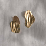 Elegant handmade AJUN earrings in recycled gold, featuring a textured, wavy design, symbolizing sustainable jewelry.