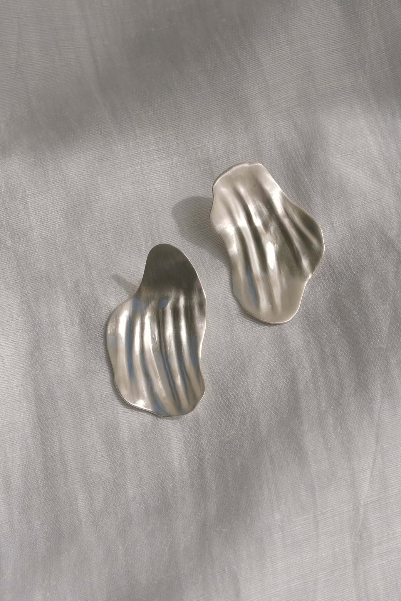 AJUN earrings made of recycled silver, showcasing a matte surface and timeless handmade design, highlighting ethical jewelry.