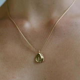 AJUN necklace in 18k gold plate, showcasing ethical, handmade jewelry on a model's neck.