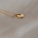 AJUN handmade necklace with a recycled gold pendant on a delicate chain, showcasing sustainable ethical jewelry.
