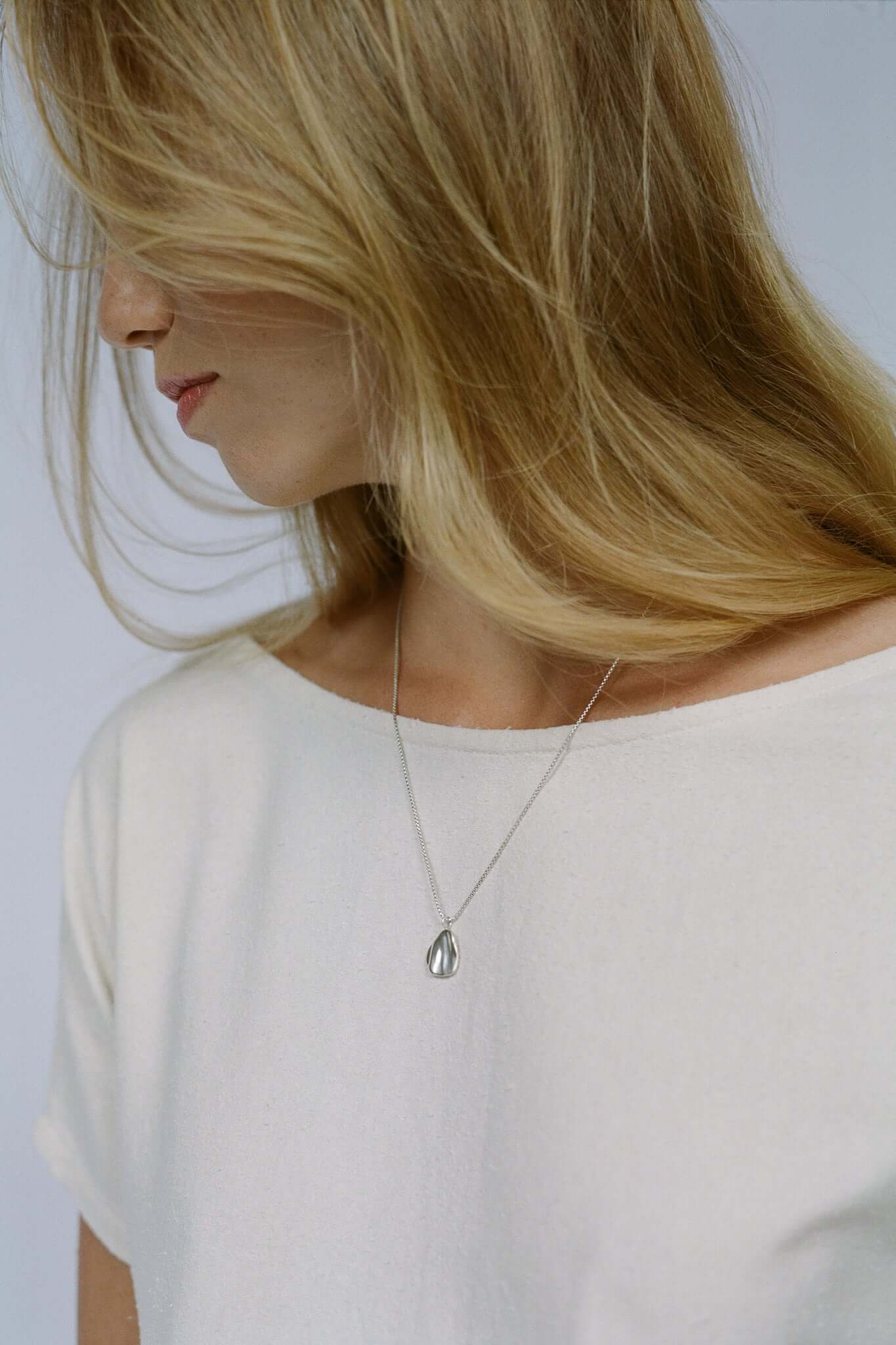 Model wearing AJUN necklace made of recycled silver, showcasing ethical, handmade, and sustainable jewelry design.