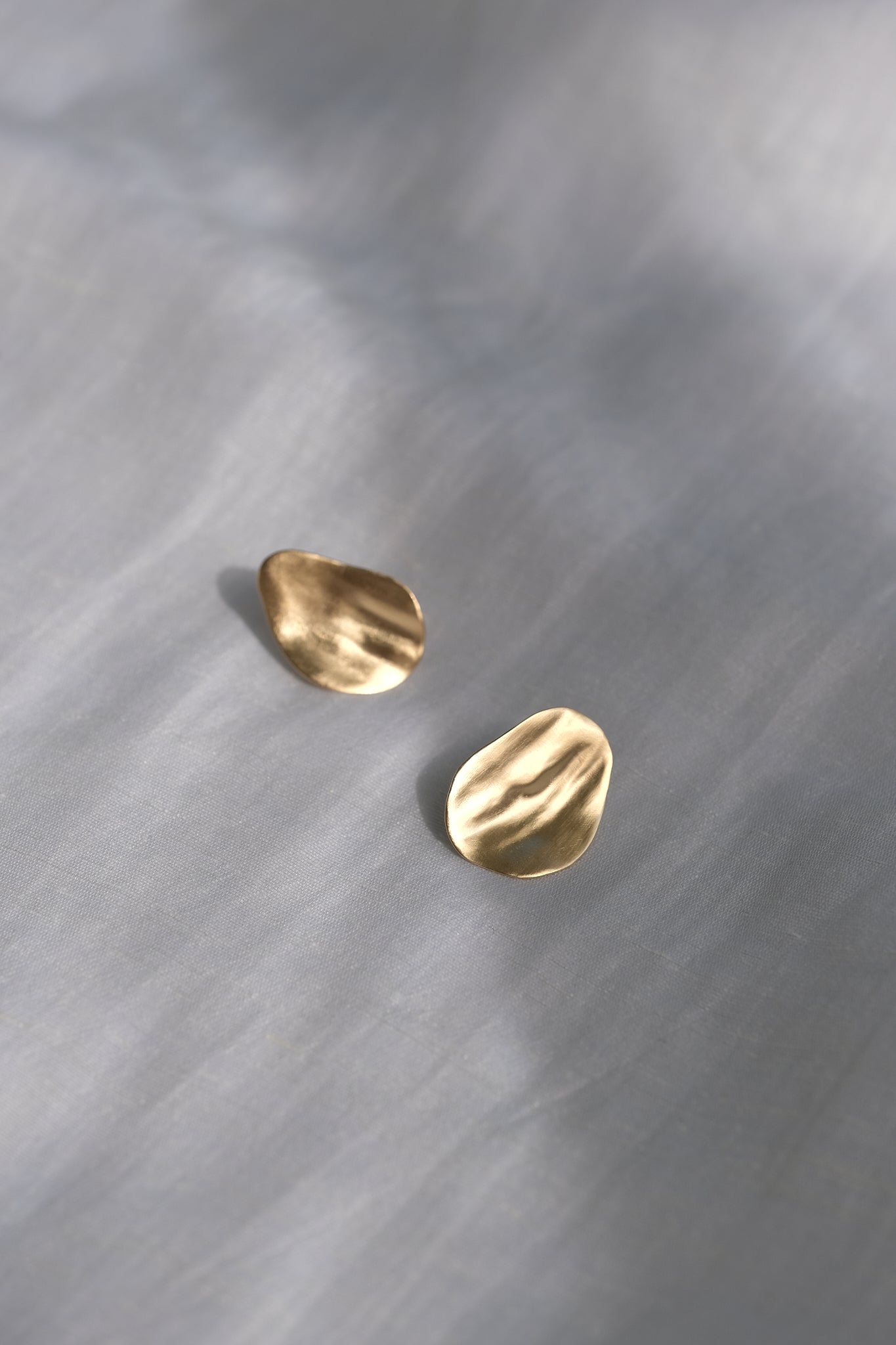 EIRA solo earrings in 18k recycled gold with matte surface, showcasing ethical handmade jewelry.