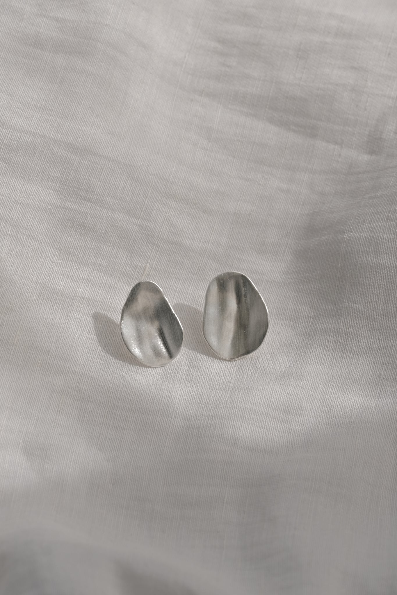 EIRA solo earrings in recycled silver with matte surface, handmade ethical jewelry, sustainable style.