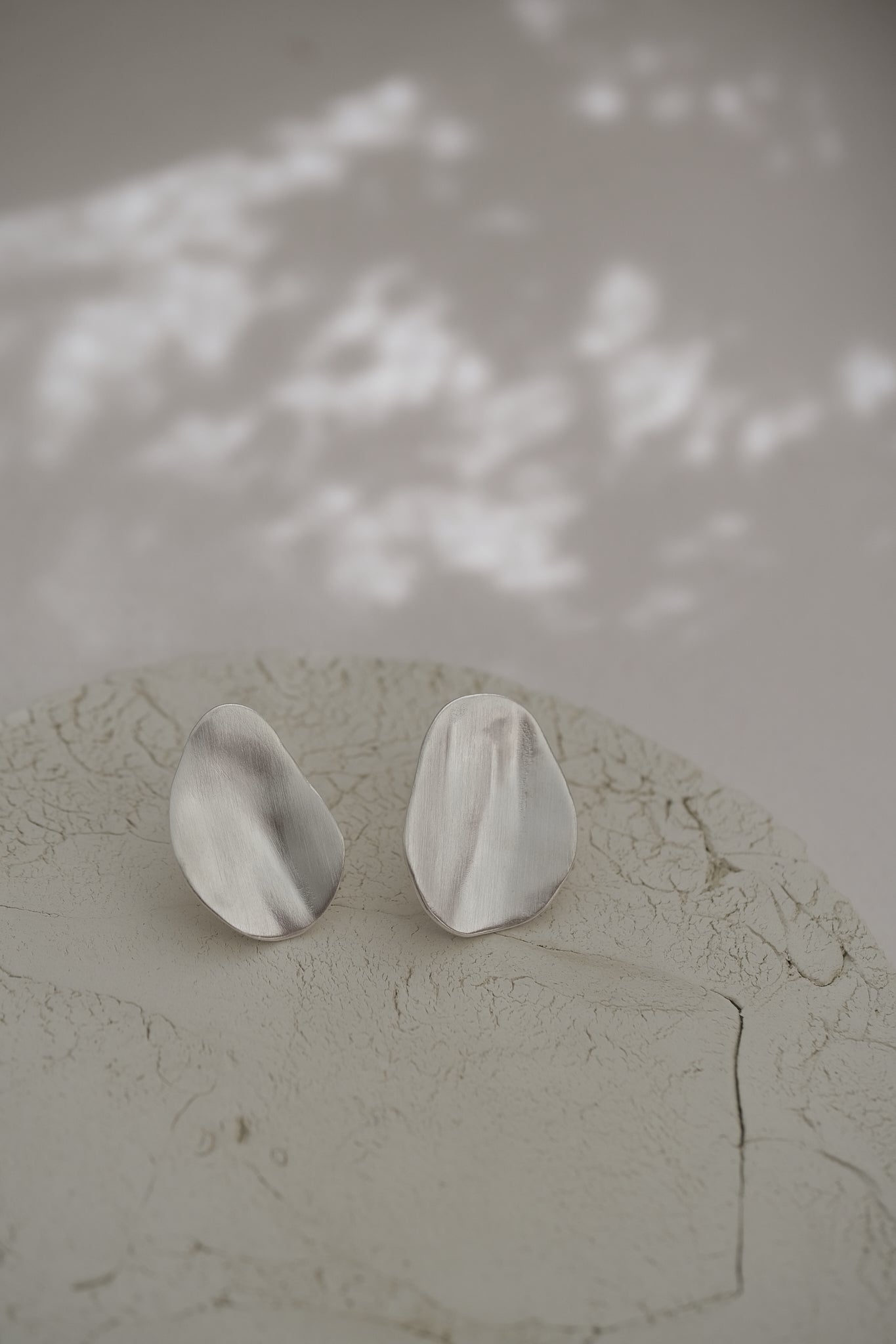 EIRA solo earrings in recycled silver with asymmetrical matte finish, handmade ethical jewelry.