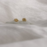 Handcrafted 18k recycled gold earrings on soft white fabric, designed and produced in Basel, Switzerland.