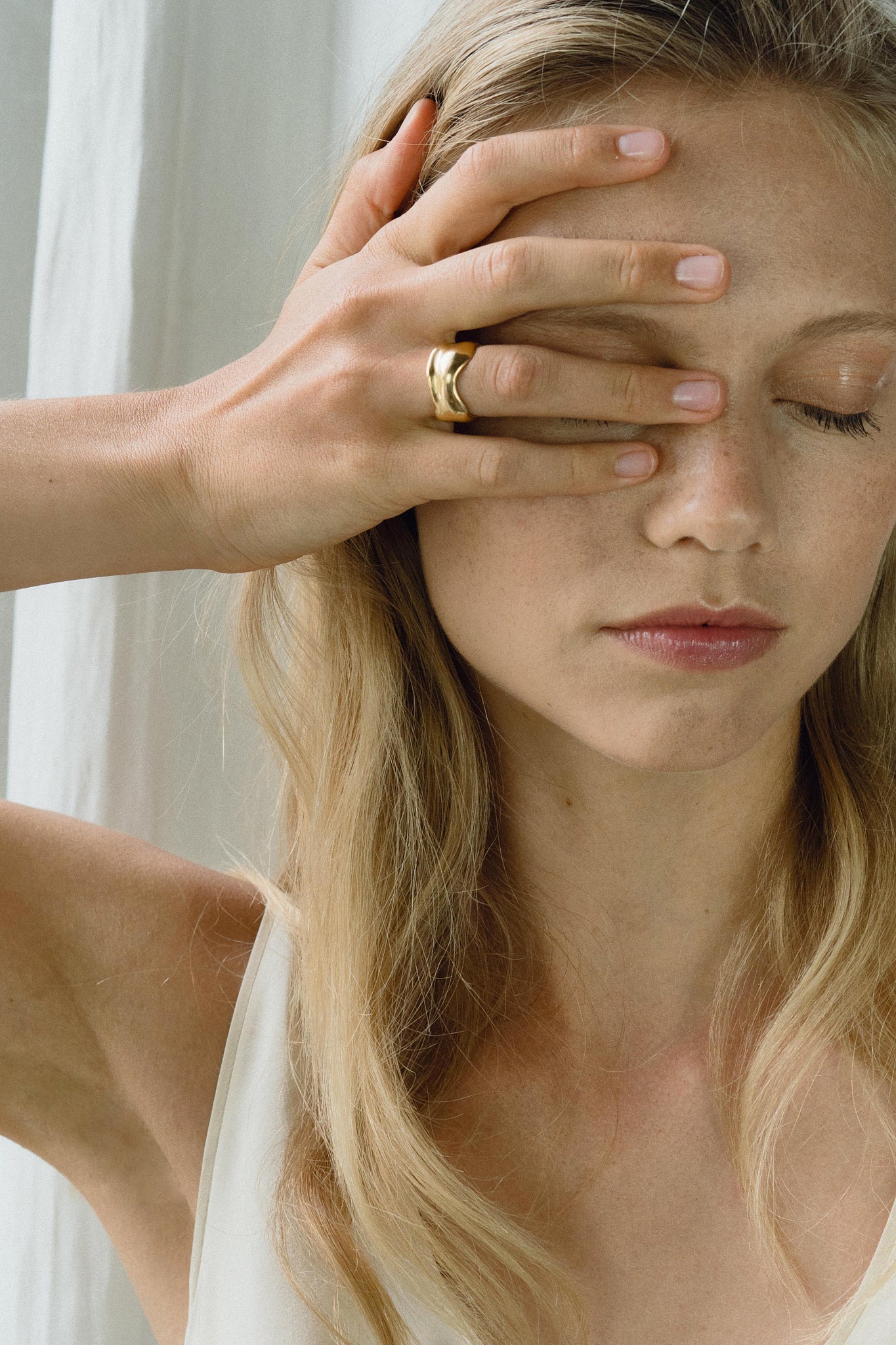 Woman wearing KAYU ring, showcasing ethical handmade jewelry made of recycled gold and silver.