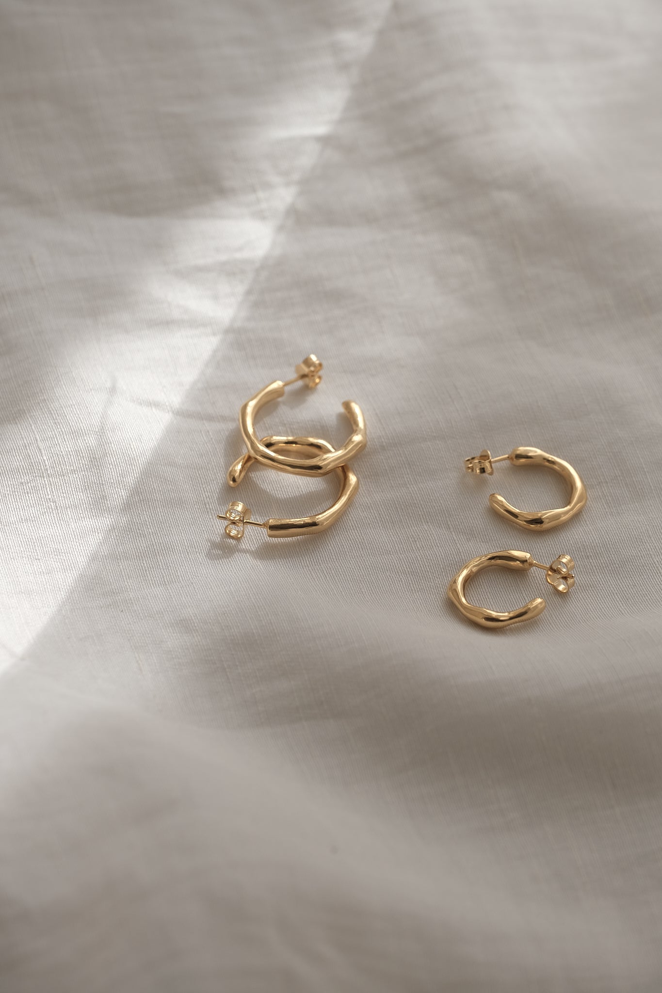 LUMI small earrings in recycled gold and silver, handcrafted ethically, showcasing a natural shiny surface.