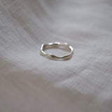 Handmade LUMI ring in recycled silver resting on soft fabric, showcasing ethical jewelry design and sustainable craftsmanship.