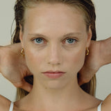 Model wearing LUMI small earrings, showcasing ethical handmade jewelry crafted from recycled gold and silver.