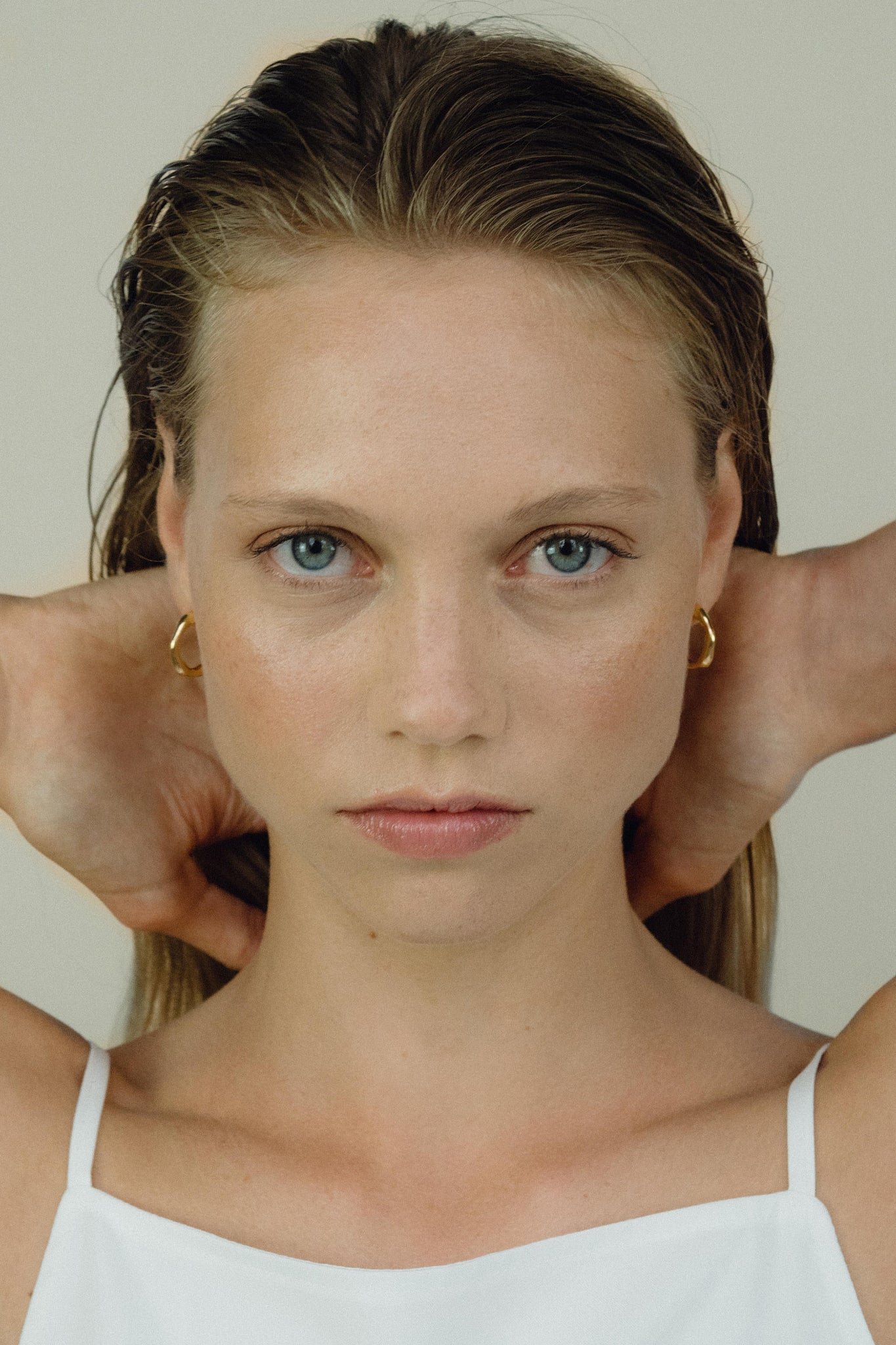 Model wearing LUMI small earrings, showcasing ethical handmade jewelry crafted from recycled gold and silver.