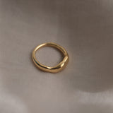 MIRU ring made from recycled gold, showcasing a natural shiny surface on a soft fabric background.