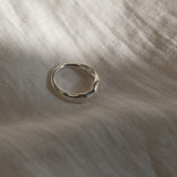 MIRU ring in recycled silver resting on soft fabric, highlighting its handmade and sustainable design.