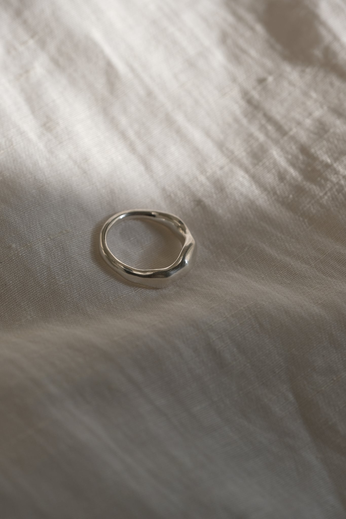 MIRU ring in recycled silver resting on soft fabric, highlighting its handmade and sustainable design.