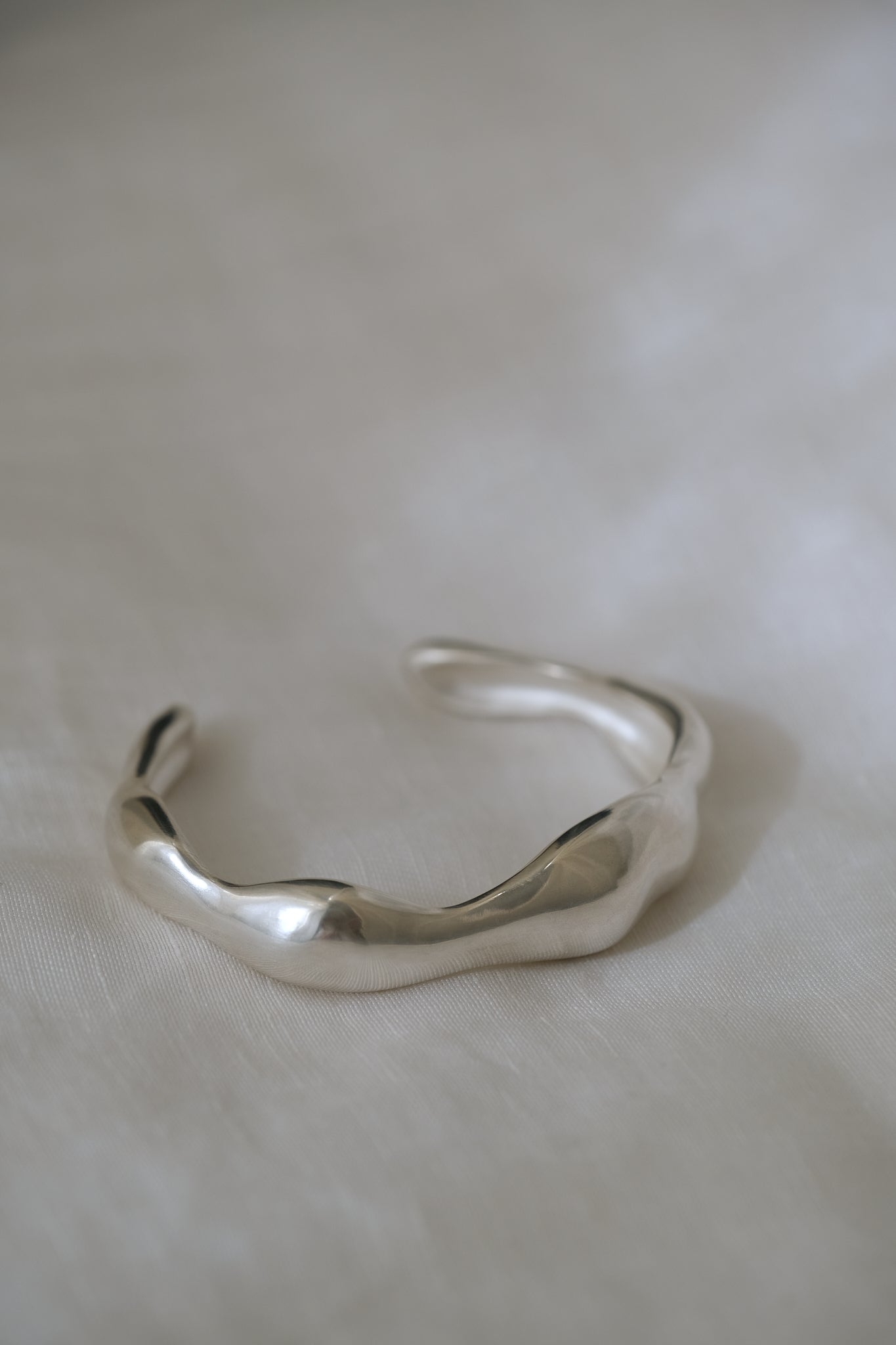 Handmade MOA cuff in recycled silver, showcasing a natural shiny surface of ethical jewelry.