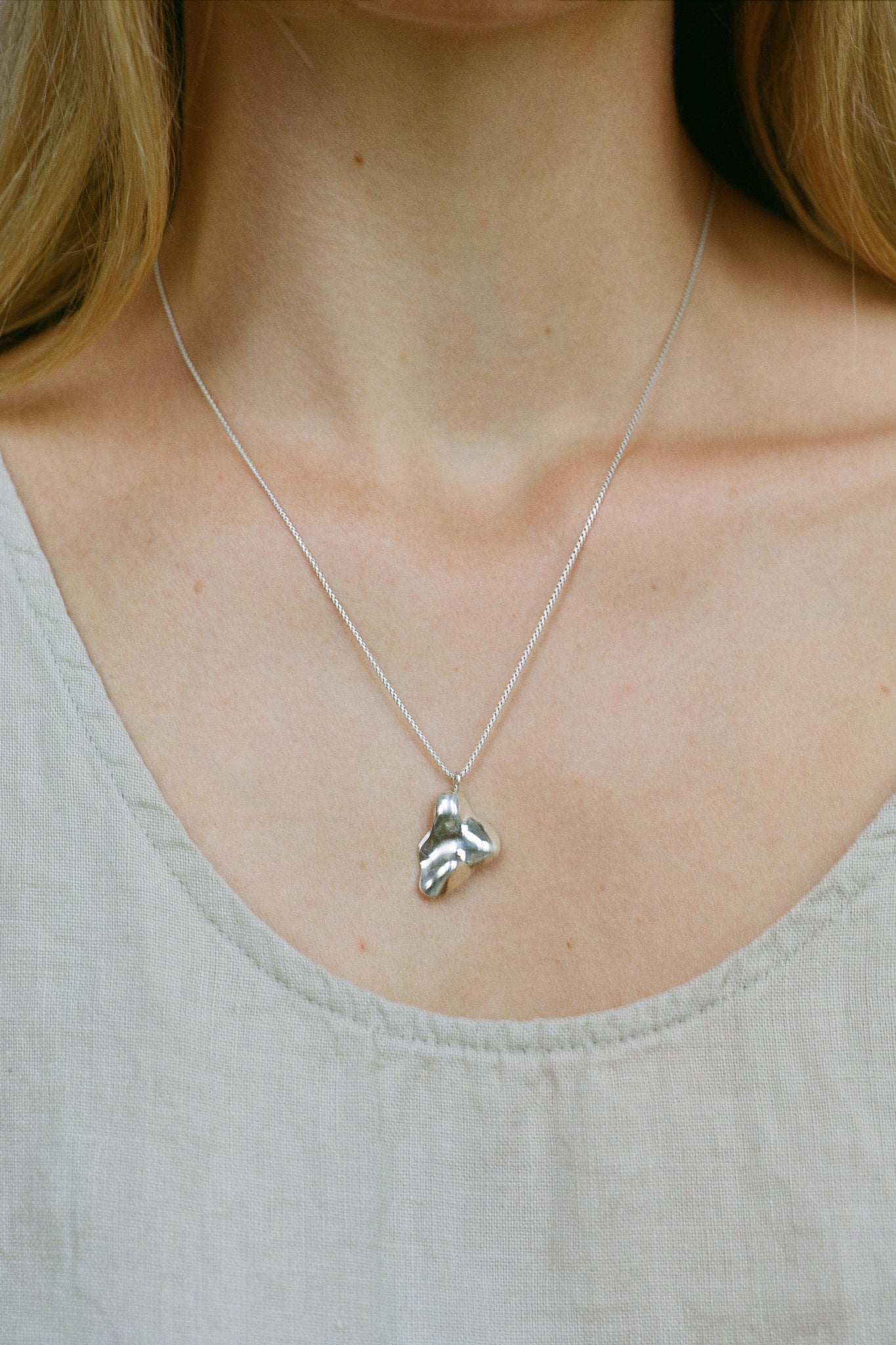 Handmade MOA necklace featuring recycled silver pendant on a delicate chain, showcasing ethical jewelry craftsmanship.