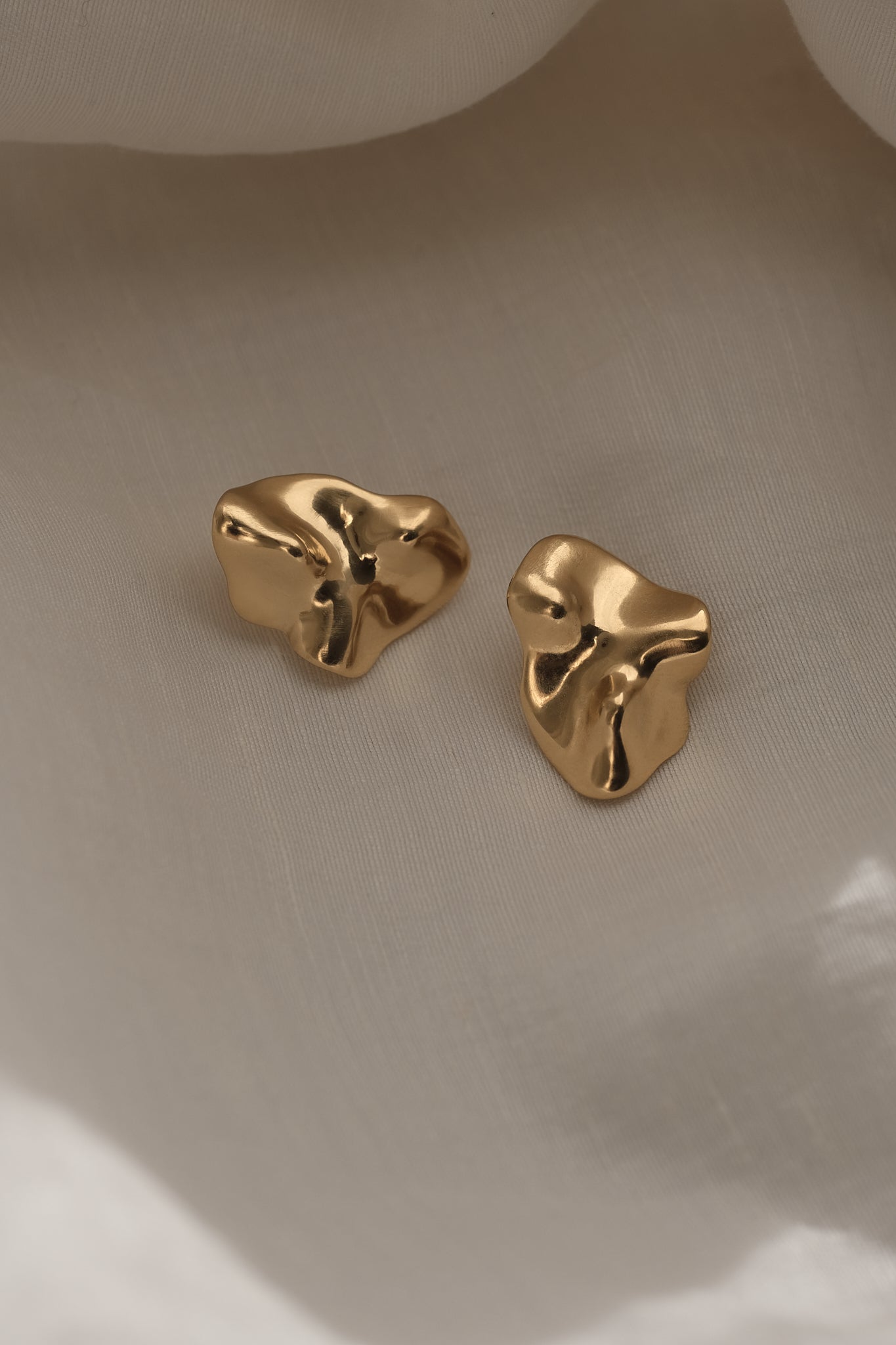 Handmade MOA earrings in 18k gold-plated recycled silver, featuring a unique organic design, showcasing ethical jewelry craftsmanship.