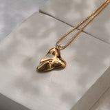 Handmade MOA necklace in 18k recycled gold on a minimalist display, showcasing sustainable and ethical jewelry.
