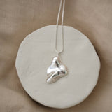 Handmade MOA necklace featuring a unique recycled silver pendant on a minimalist display.