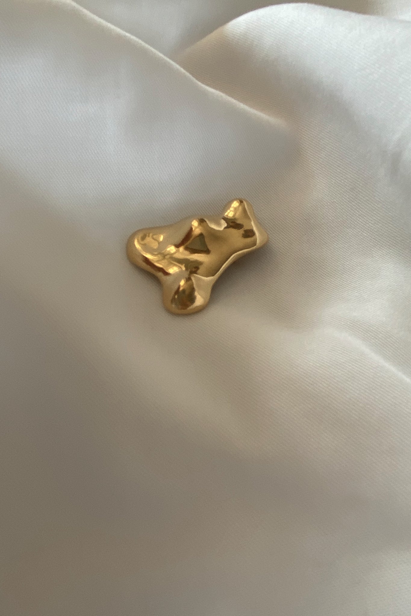 Handmade MOA brooch in 18k gold-plated recycled silver on silky fabric, showcasing sustainable, ethical jewelry.